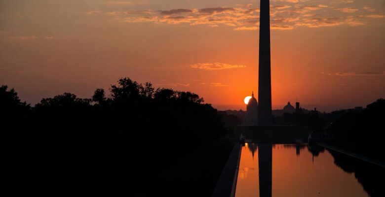 silhouette of tower during orange sunset
