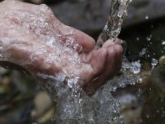 person cleaning hands under water