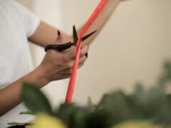 crop woman cutting ribbon for bouquet