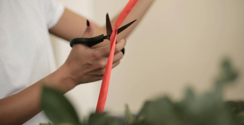 crop woman cutting ribbon for bouquet