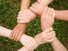 group of people holding arms