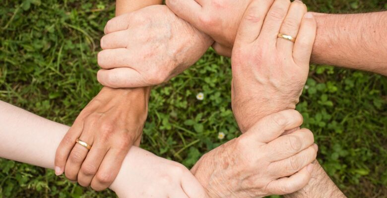 group of people holding arms