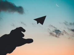 silhouette photo of man throw paper plane
