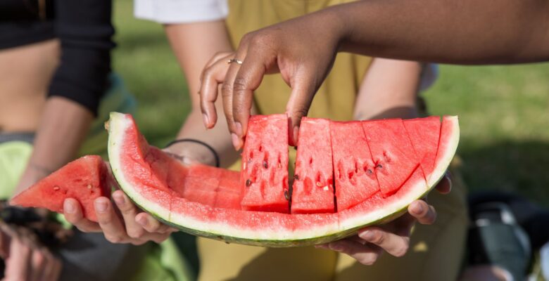 person holding sliced watermelon
